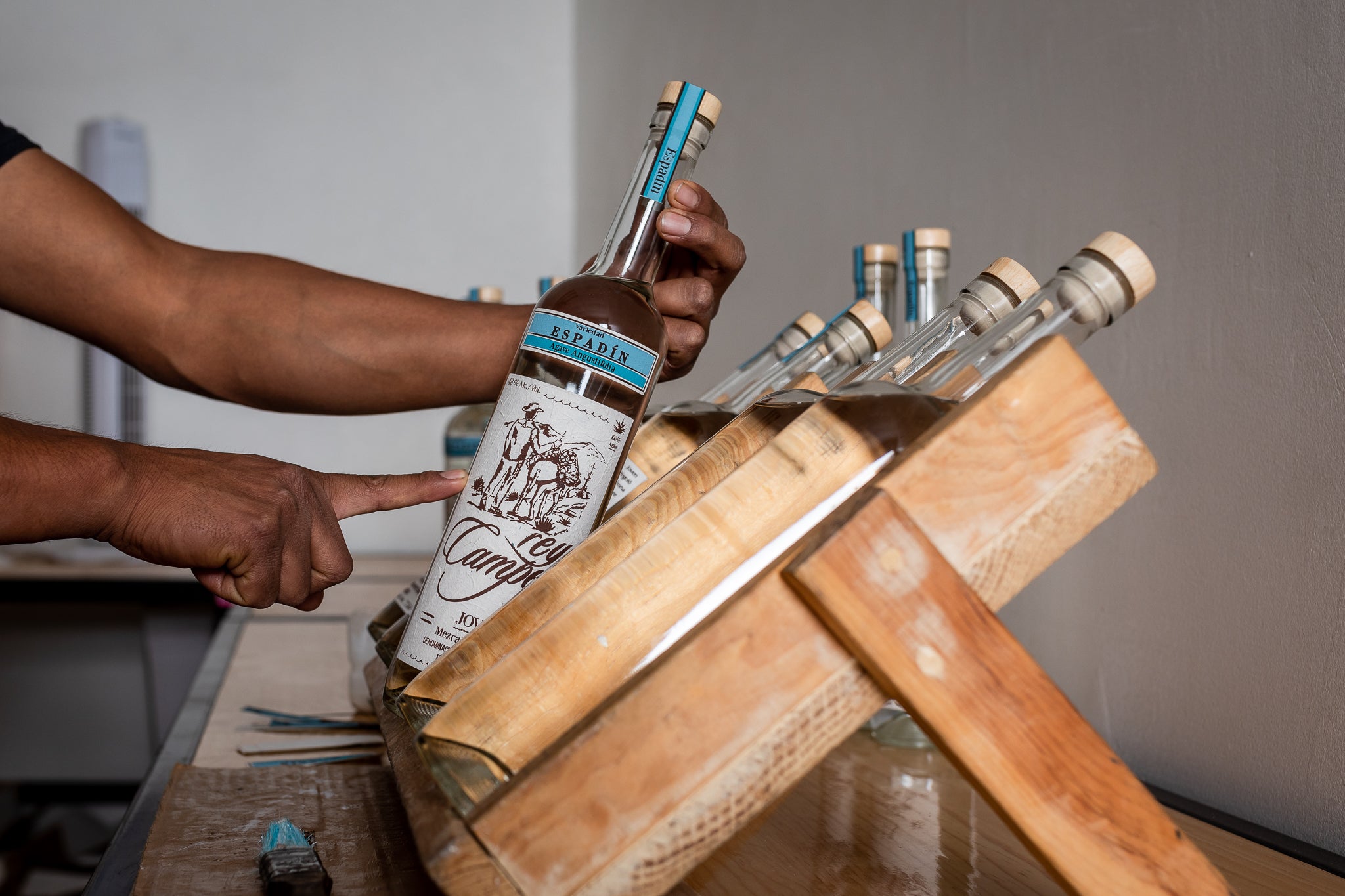 Bottle of Rey Campero Espadin Mezcal being showcased in a wooden display, highlighting its craftsmanship.