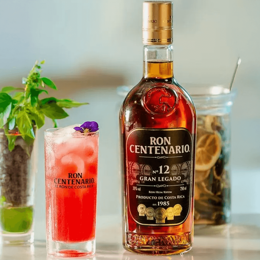 Ron Centenario 12 Year Gran Legado Rum bottle with a colorful cocktail, showcasing Costa Rican heritage and premium craftsmanship.
