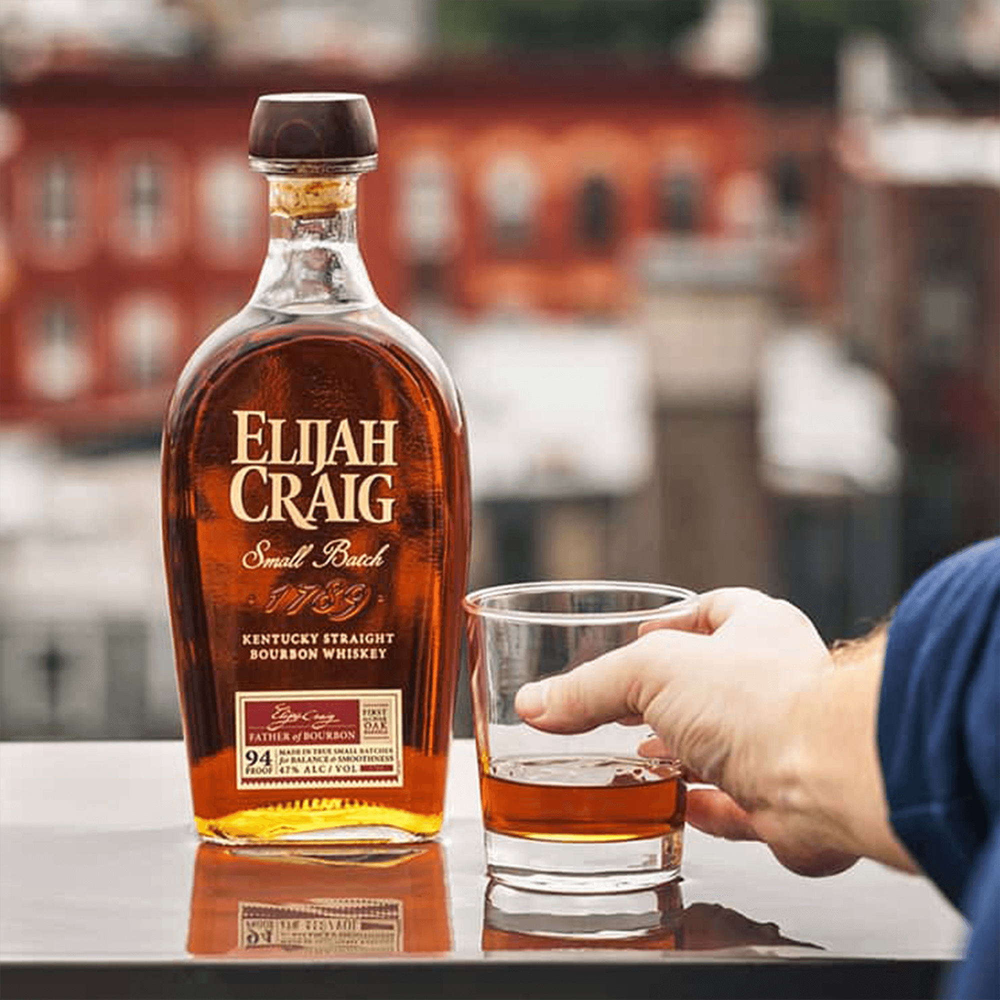 Elijah Craig Small Batch Bourbon 375ml with a glass, showcasing rich amber color and label details.