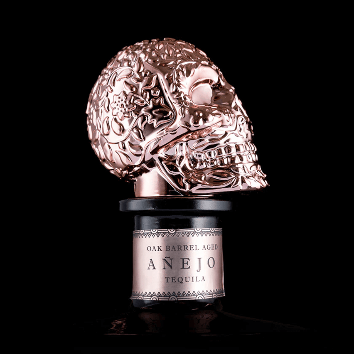 Satryna Añejo Tequila in a unique skull bottle, showcasing oak barrel aging and intricate design.