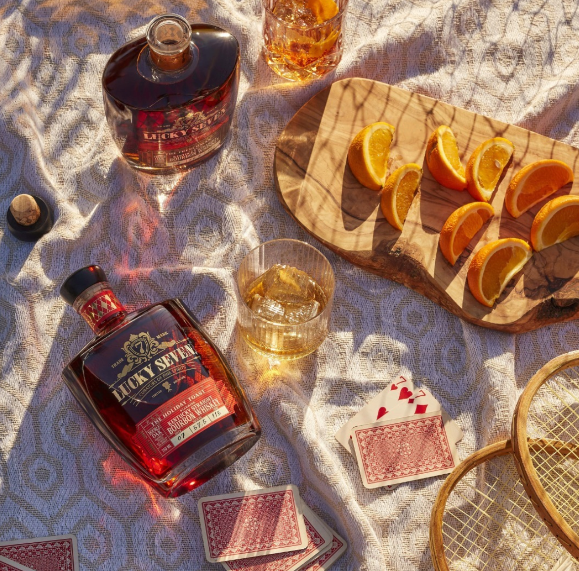 Lucky Seven Holiday Toast Bourbon with oranges and playing cards, perfect for festive celebrations.