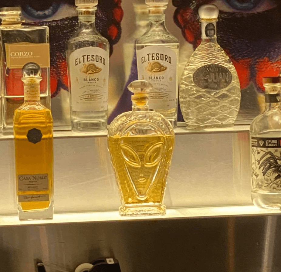 Alien Añejo Tequila bottle on display among other premium tequila brands.
