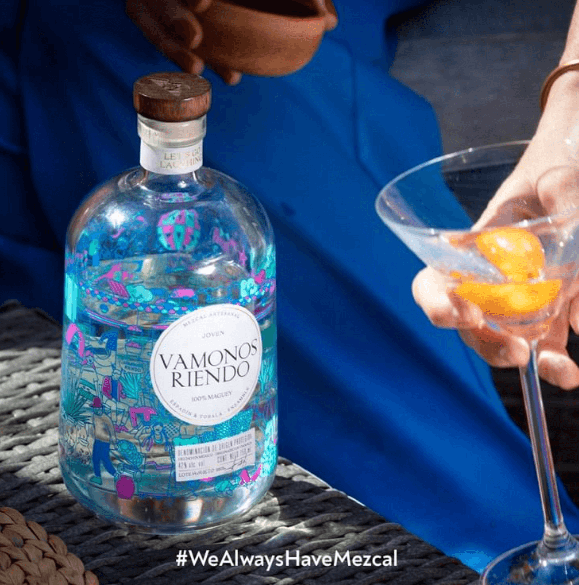 Vamonos Riendo Joven Mezcal bottle with vibrant label, served in a cocktail glass with fresh citrus garnish.