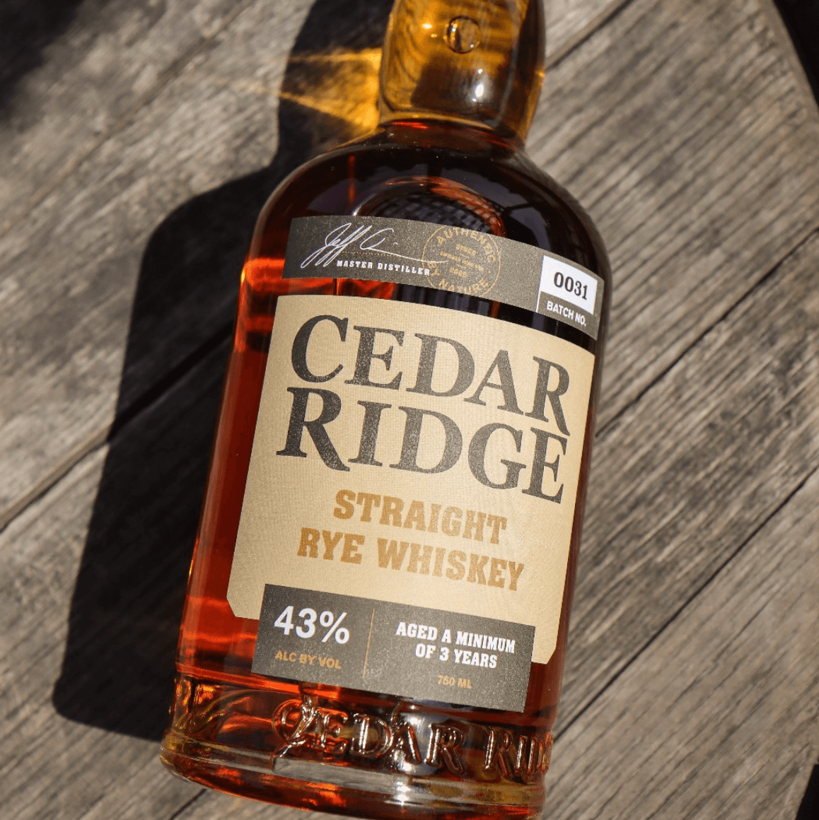 Cedar Ridge Straight Rye Whiskey bottle featuring aged label and rich amber color on wooden surface.