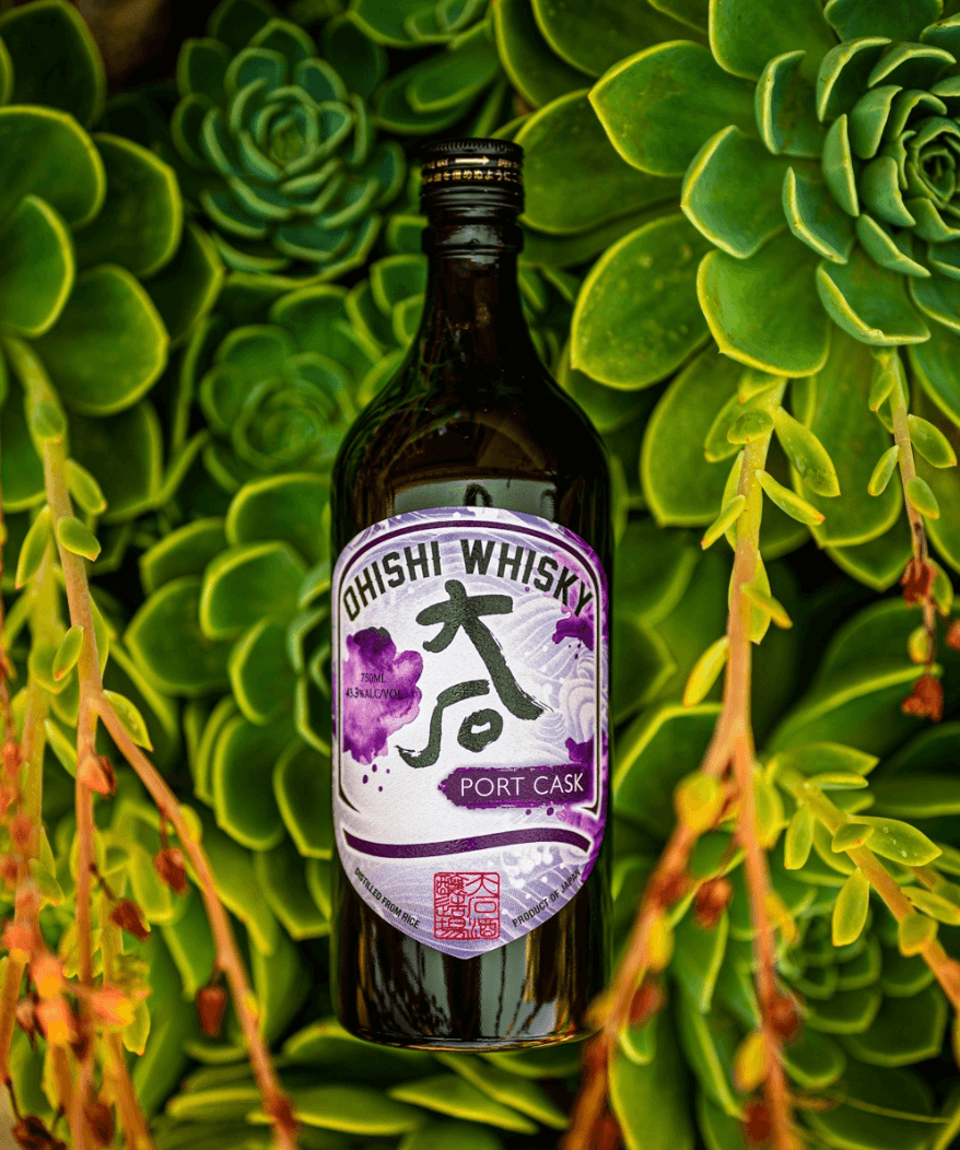 Ohishi Port Cask Japanese Whiskey bottle among lush succulent greenery.