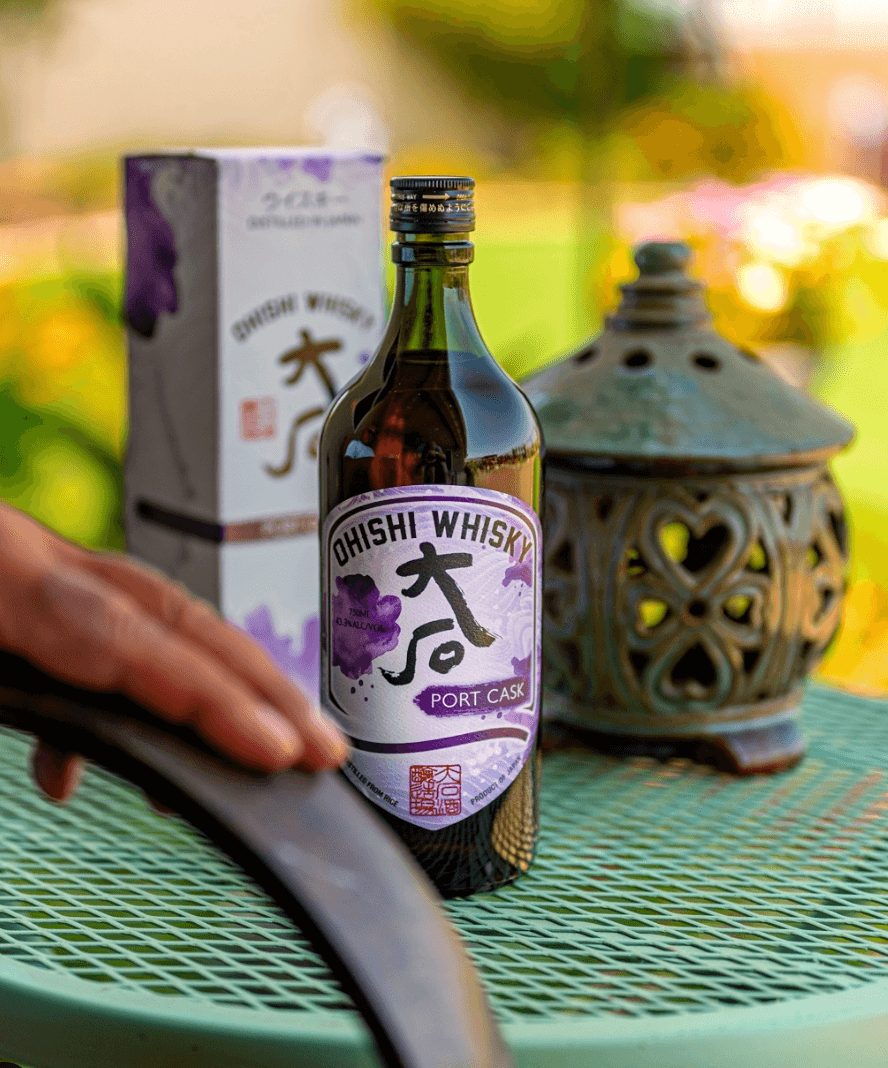 Ohishi Port Cask Japanese Whiskey bottle on a green table, showcasing elegant design and packaging.