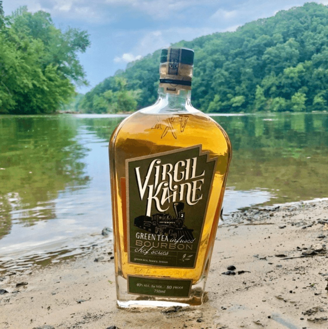 Virgil Kaine Green Tea Infused Chef Series Whiskey displayed by a river, showcasing its unique herbal infusion and rich flavor.