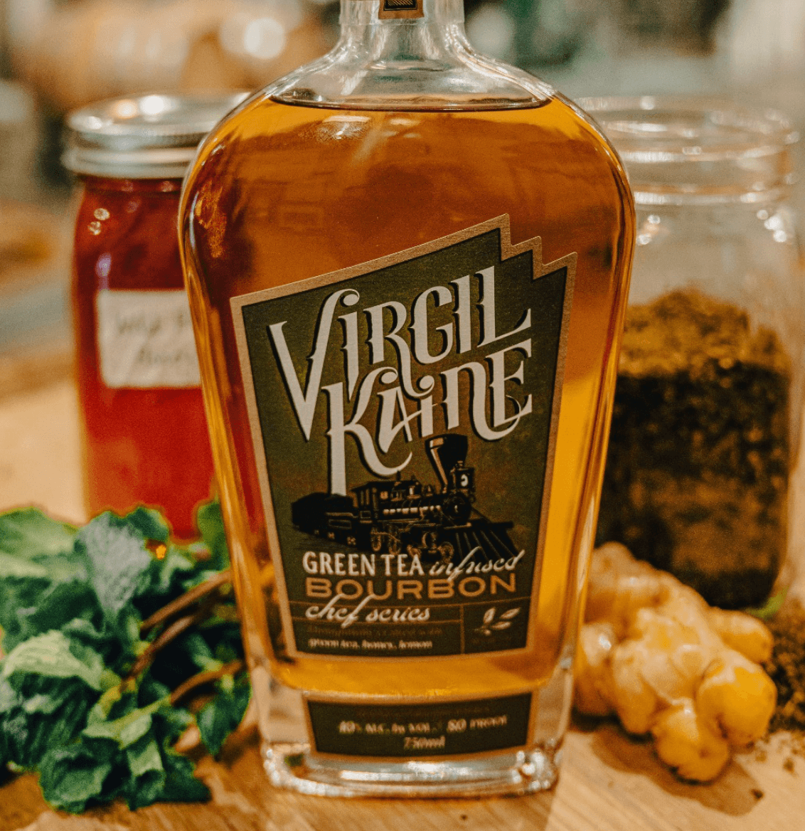 Virgil Kaine Green Tea Infused Chef Series Whiskey bottle with fresh mint and honey in the background.