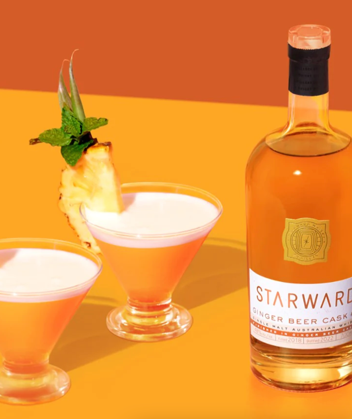 Starward Ginger Beer Cask #7 single malt whisky with cocktails on an orange background.