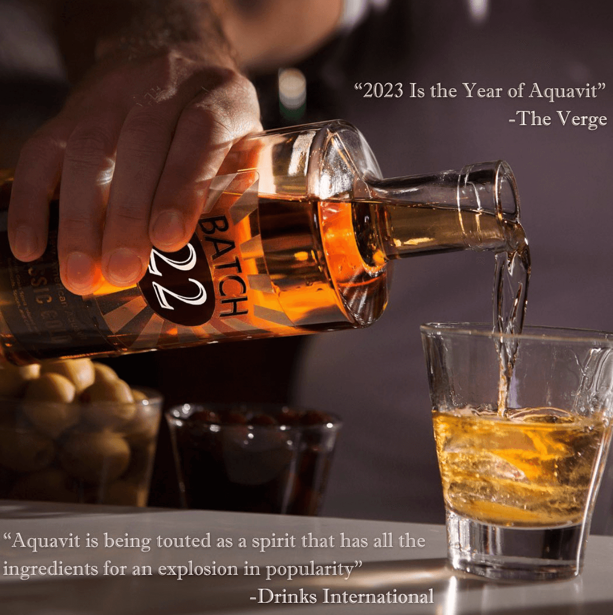 Pouring Batch 22 New American Aquavit into a glass with olives, showcasing its unique flavor and versatility.