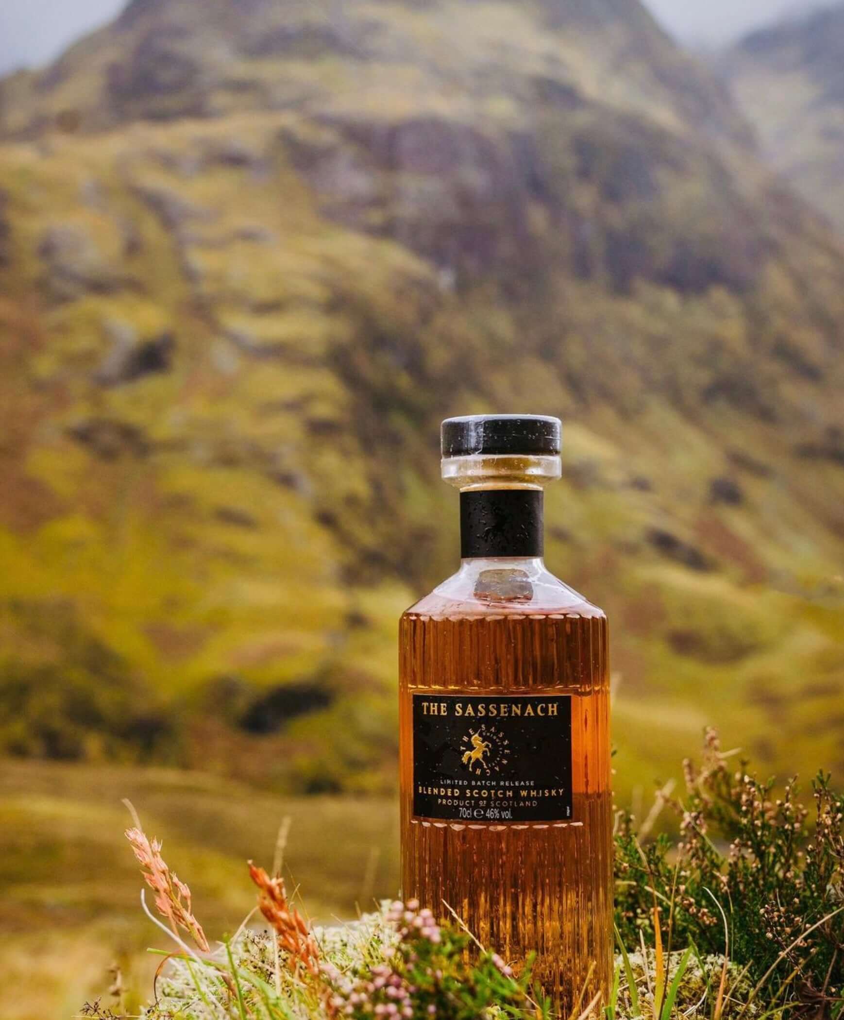 The Sassenach blended Scotch whisky bottle set against a Highland landscape, showcasing its rich character and smooth flavor.