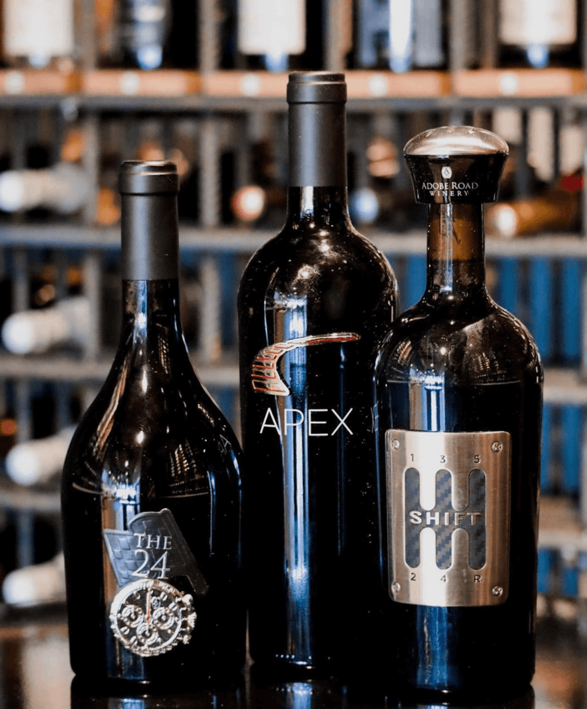 Three wine bottles: The 24 Red Blend, Apex, and Shift, showcasing elegant design in a wine display.