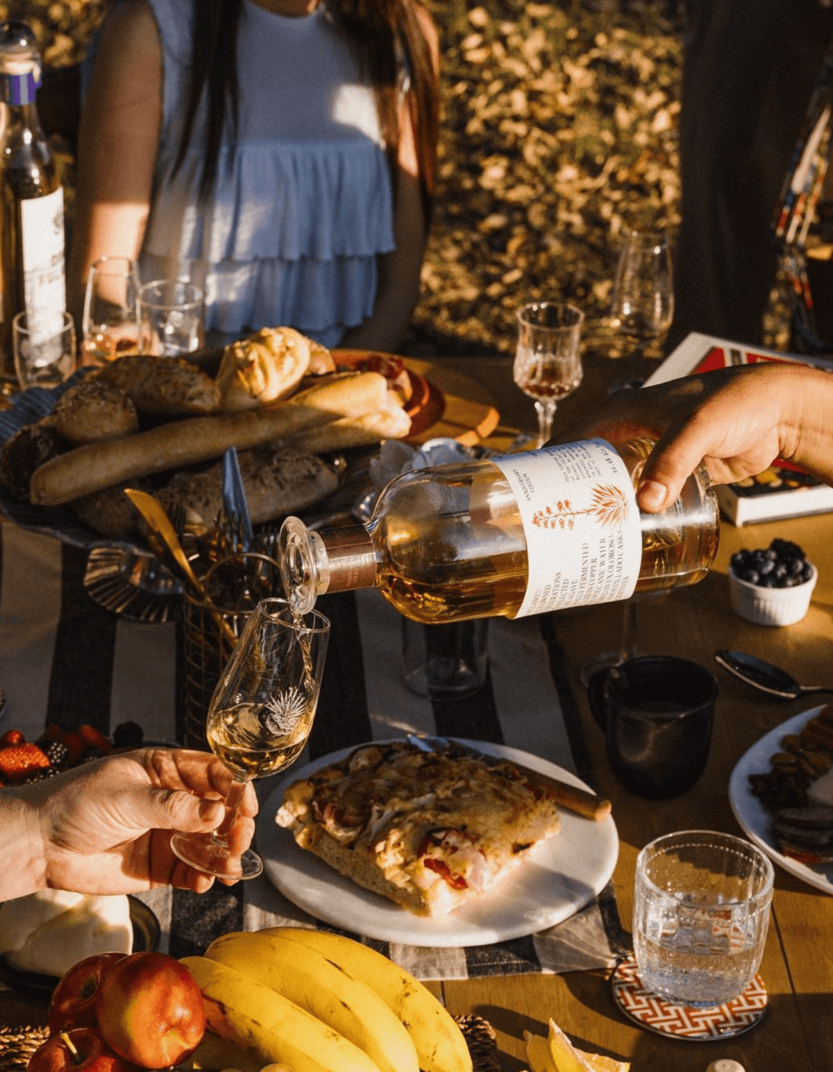 Celebratory gathering featuring Don Fulano Añejo Tequila being poured into a glass with a delicious spread of food.