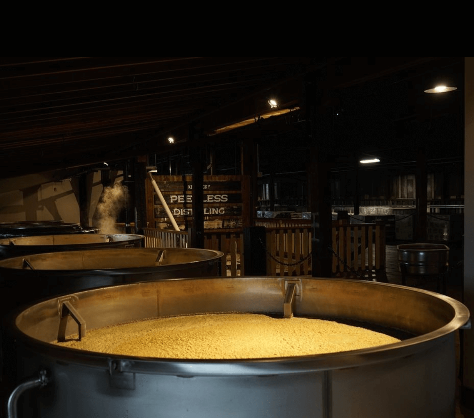 Large fermentation tanks at Peerless Distilling, showcasing the whiskey-making process.