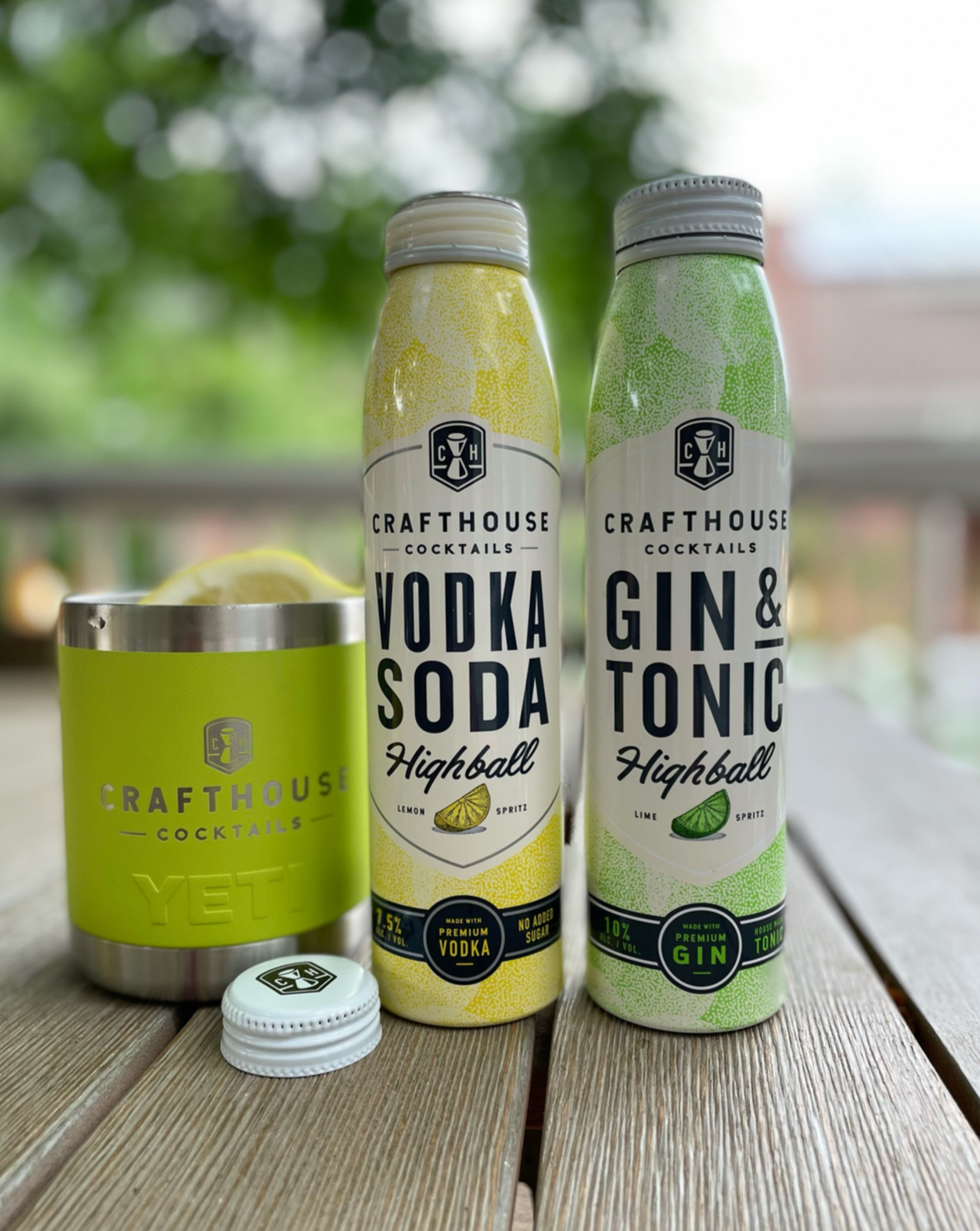 Crafthouse Cocktails Gin and Tonic and Vodka Soda cans beside a YETI cup outdoors.