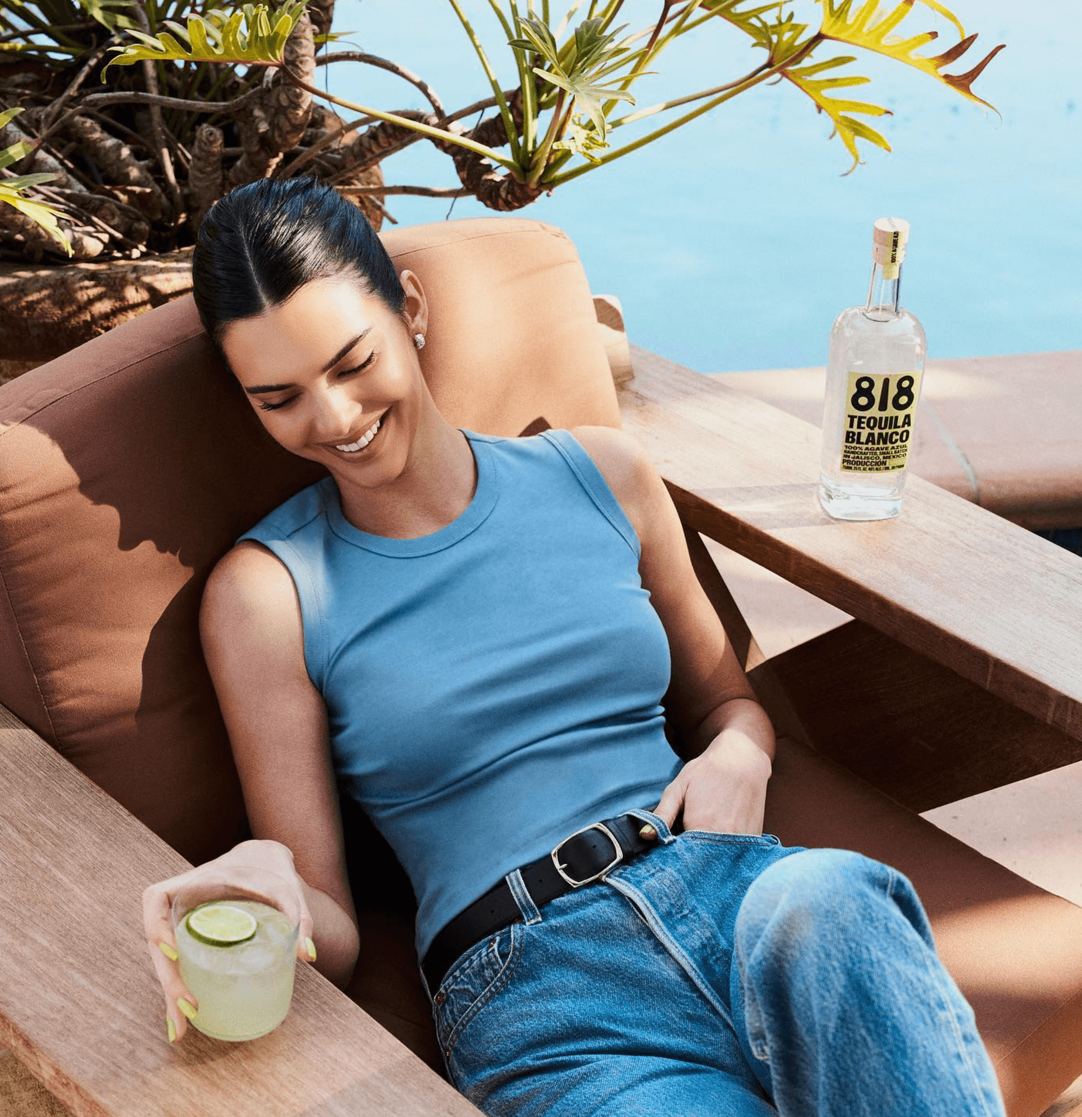 Kendall Jenner enjoying a cocktail with 818 Blanco Tequila by the pool, showcasing luxury and relaxation.