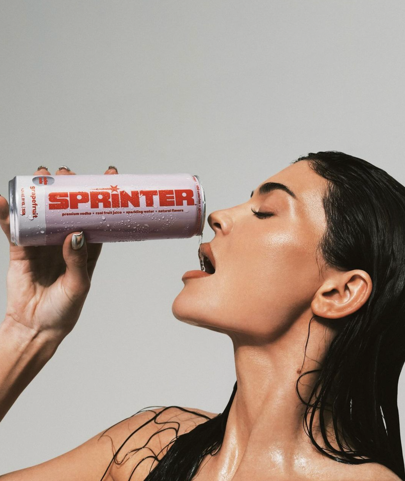 Close-up of a woman enjoying a Sprinter Vodka Soda can with a sleek design and vibrant branding.