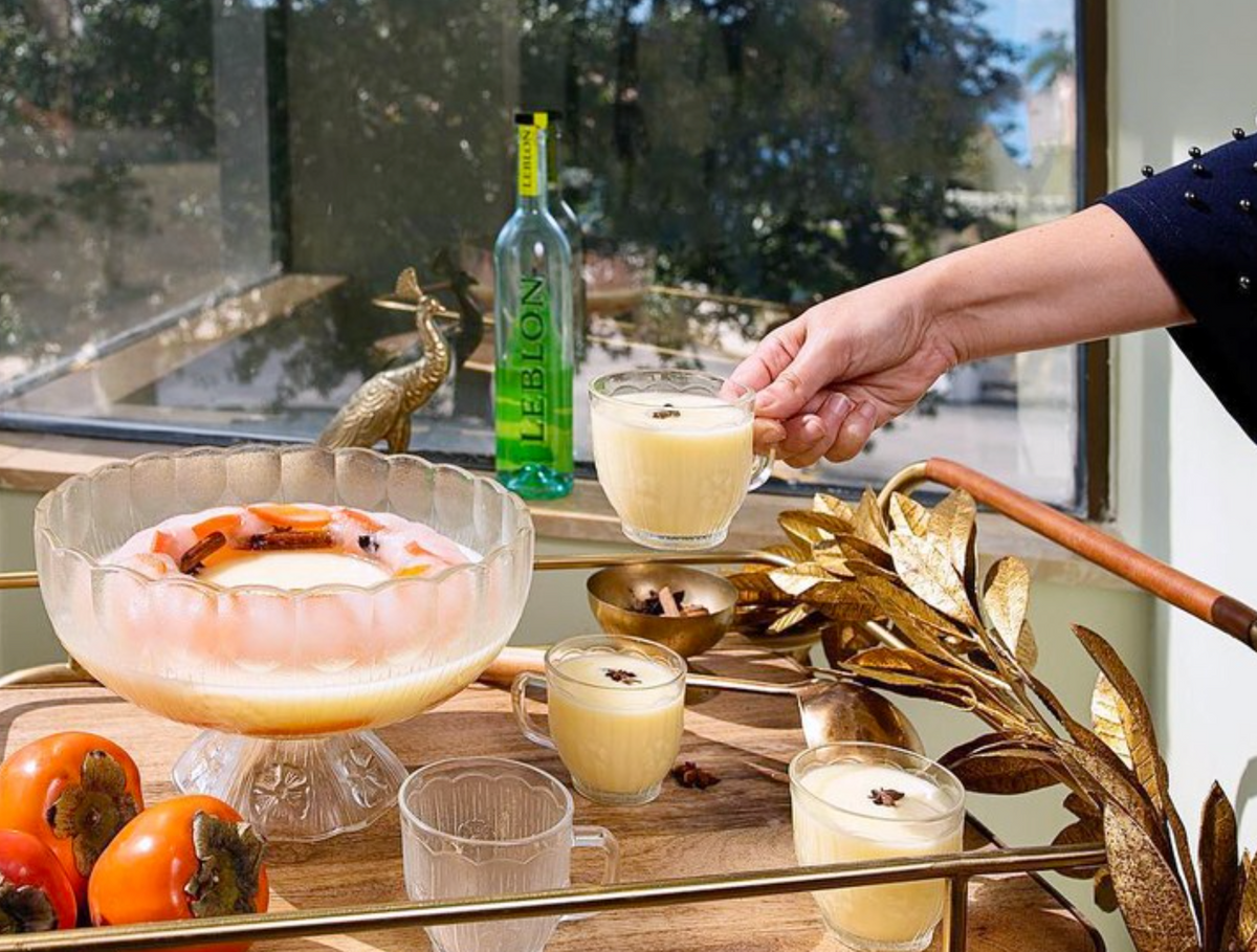 Leblon Cachaça cocktail served in elegant glassware, surrounded by decor and fresh fruit on a stylish table.