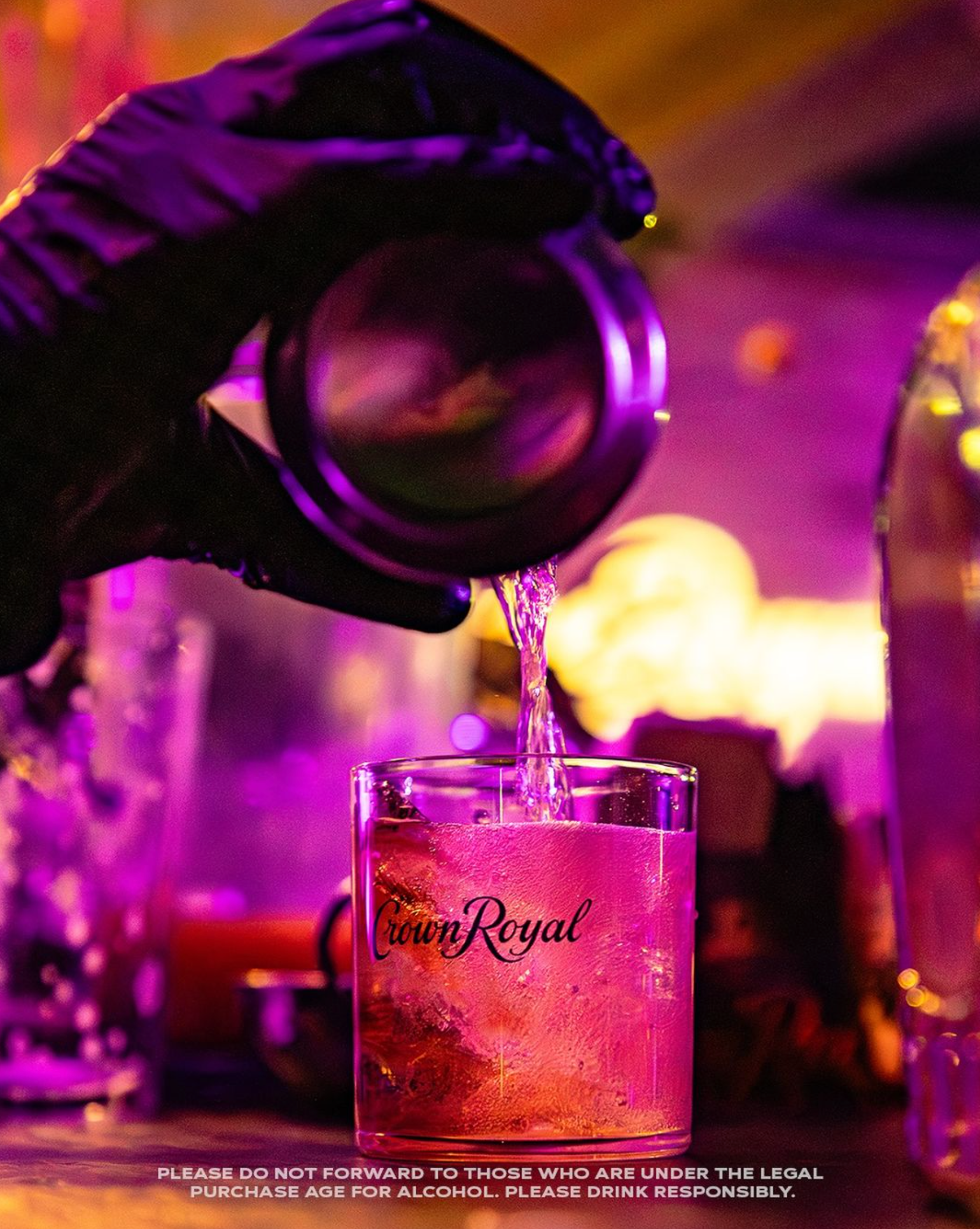 Pouring Crown Royal Blackberry Whiskey into a glass with a vibrant atmosphere, showcasing summer flavors.