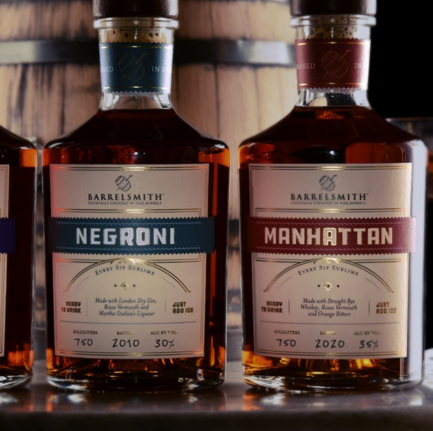 Barrelsmith Manhattan Cocktail and Negroni bottles, showcasing premium rye whiskey and vermouth, aged in oak barrels.