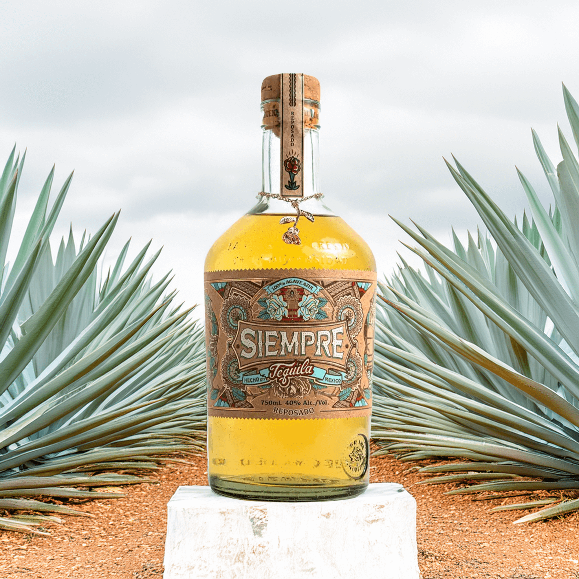 Siempre Reposado Tequila bottle in an agave field, showcasing its unique oak aging and vibrant flavors.