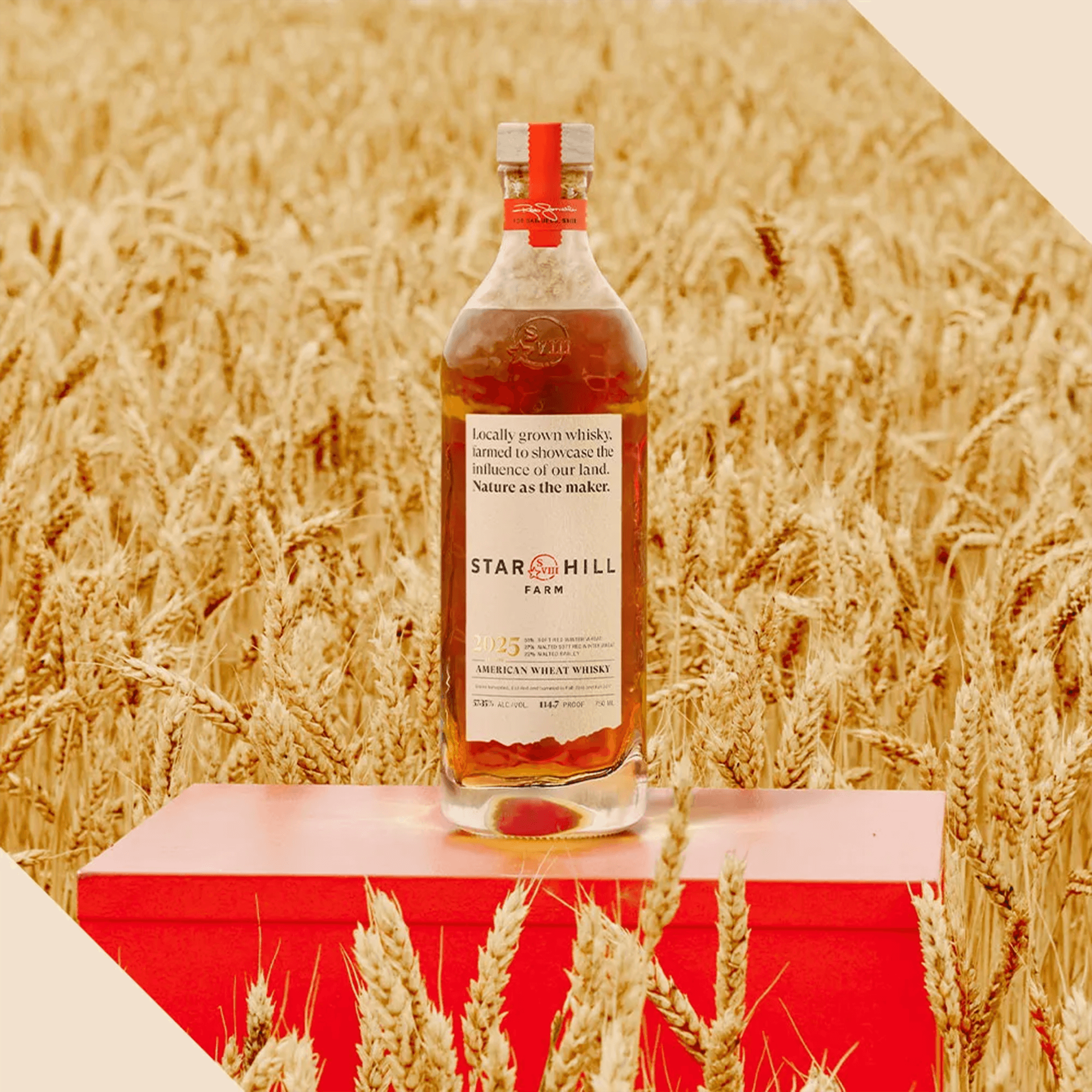 Star Hill Farm American wheat whisky bottle surrounded by golden wheat fields, showcasing its artisanal heritage.