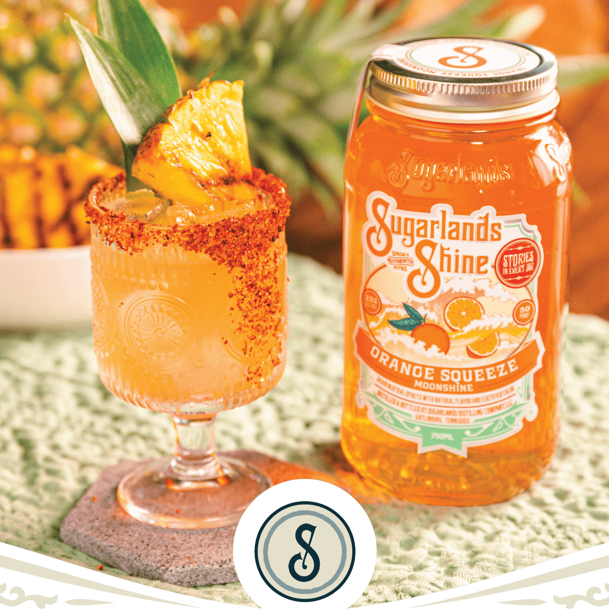 Enjoy a refreshing Sugarlands Shine Orange Squeeze moonshine cocktail served in a glass with a pineapple garnish.