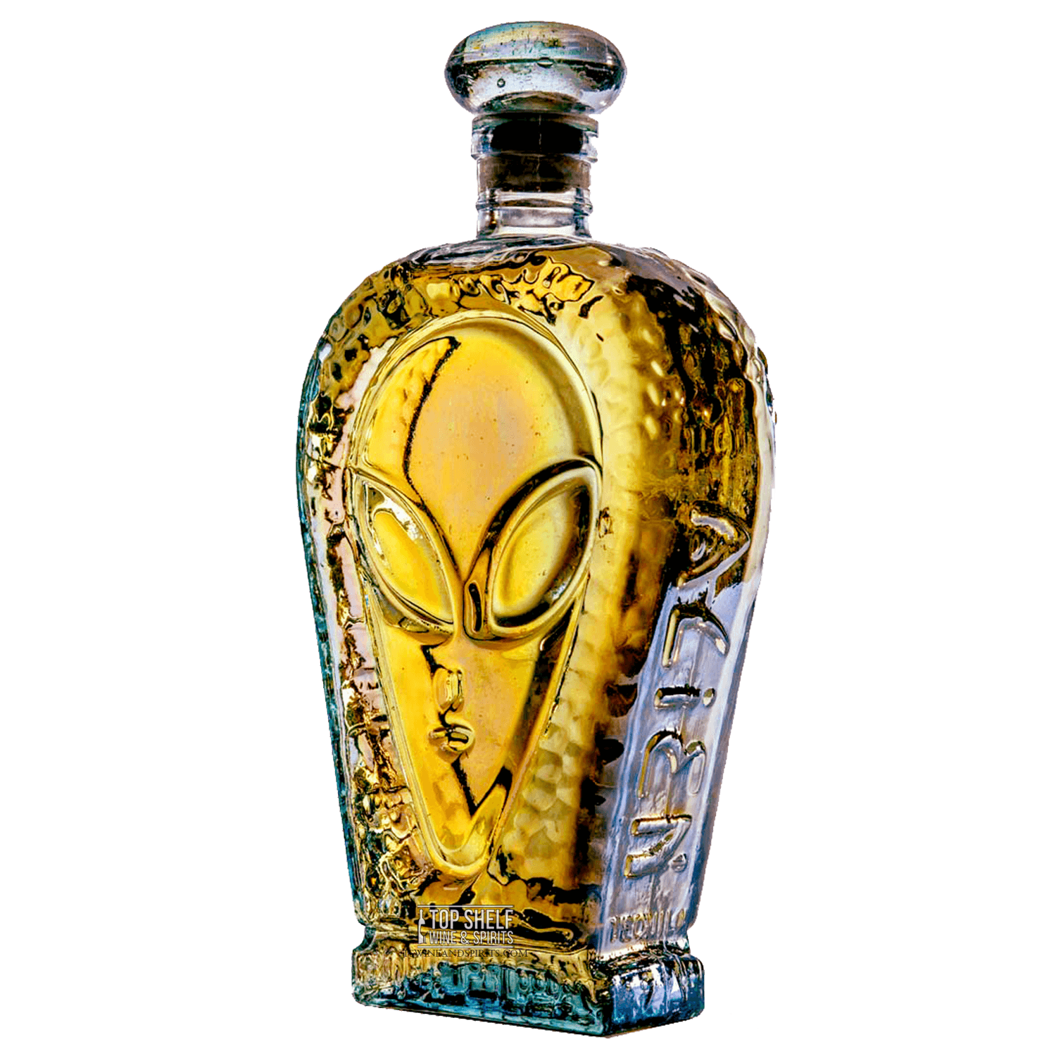 Alien Añejo Tequila bottle, amber color with gold hues, crafted from 100% Blue Agave in Jalisco, Mexico.