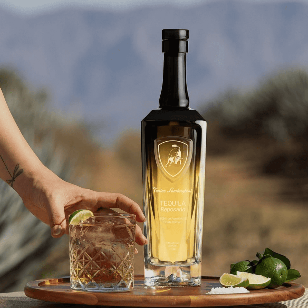 Tonino Lamborghini Reposado Tequila served on a wooden tray with glass and lime, showcasing Italian design in a natural setting.