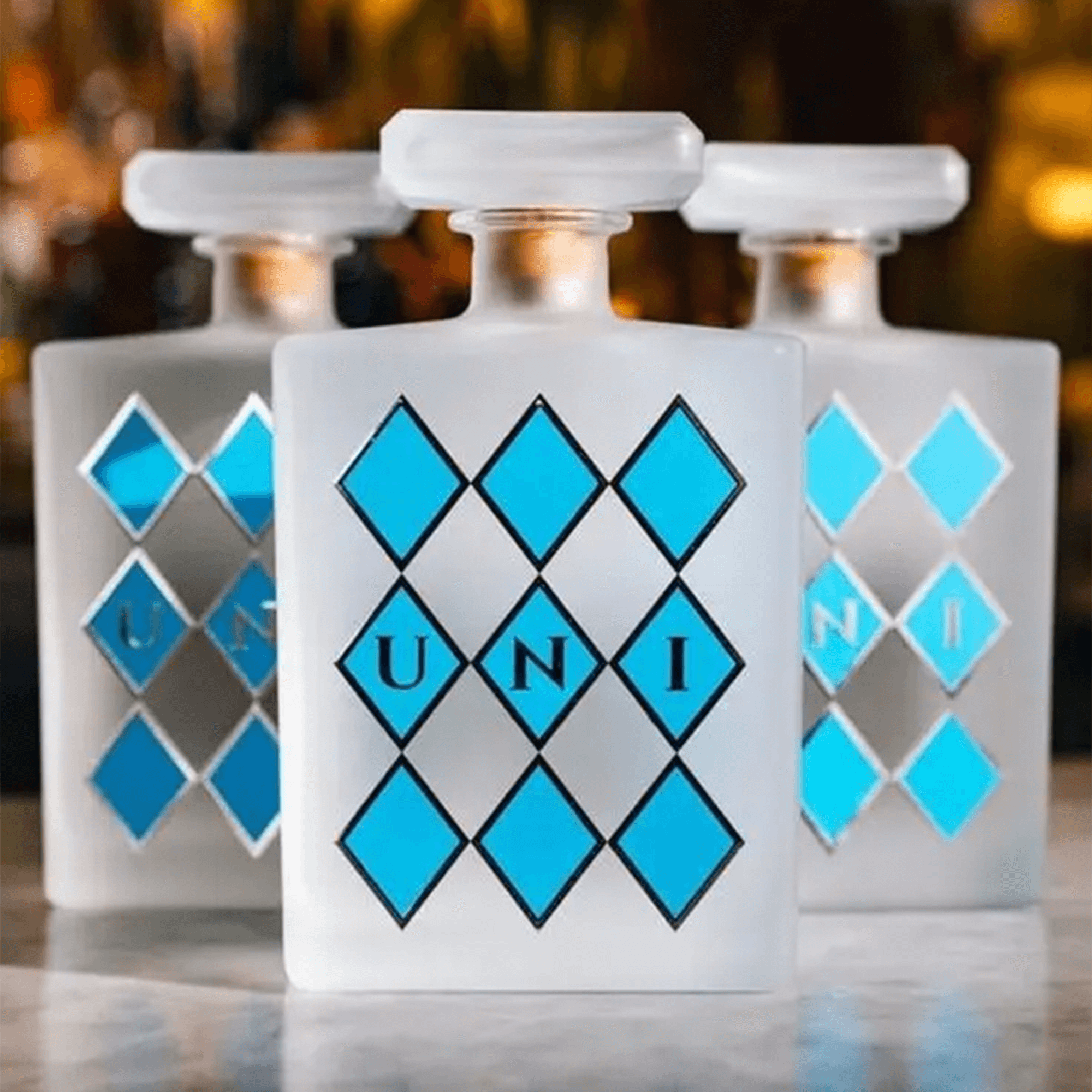 Elegant Uni Organic Blanco Tequila bottles with blue diamond designs, showcasing premium craftsmanship.
