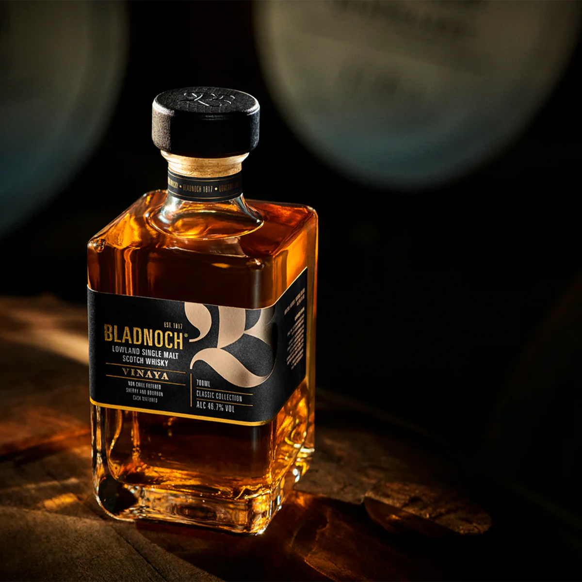Bladnoch Vinaya Classic Collection Lowland Single Malt whiskey bottle on wooden surface, showcasing rich amber color.