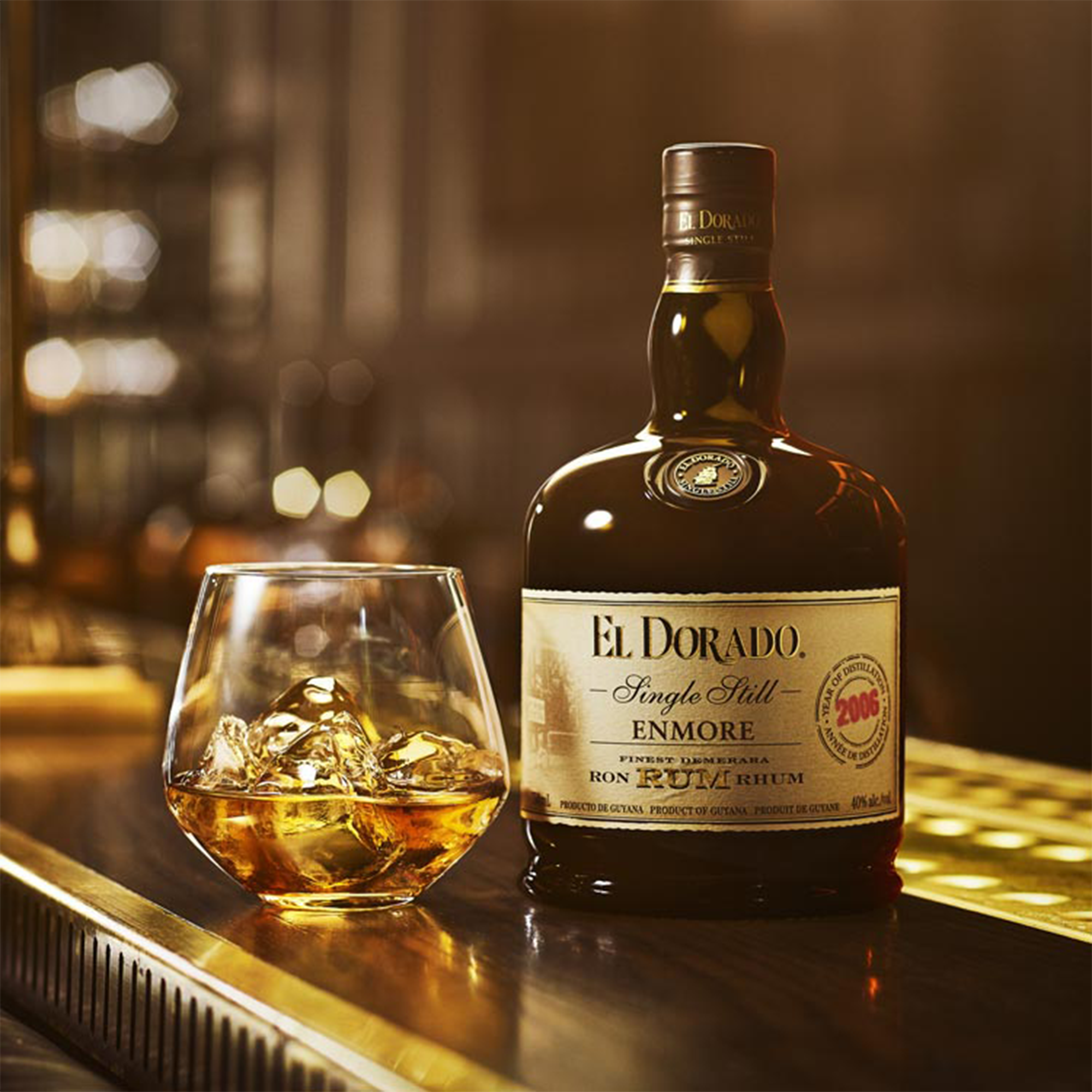 El Dorado Enmore Cask Strength Rum bottle with a glass of rum on a bar countertop.