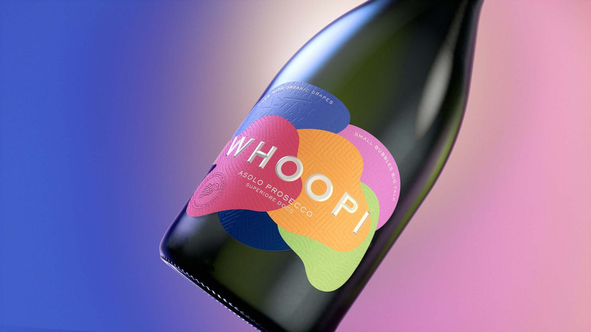 Whoopi Goldberg Prosecco bottle showcasing vibrant label and elegant design against a colorful backdrop.