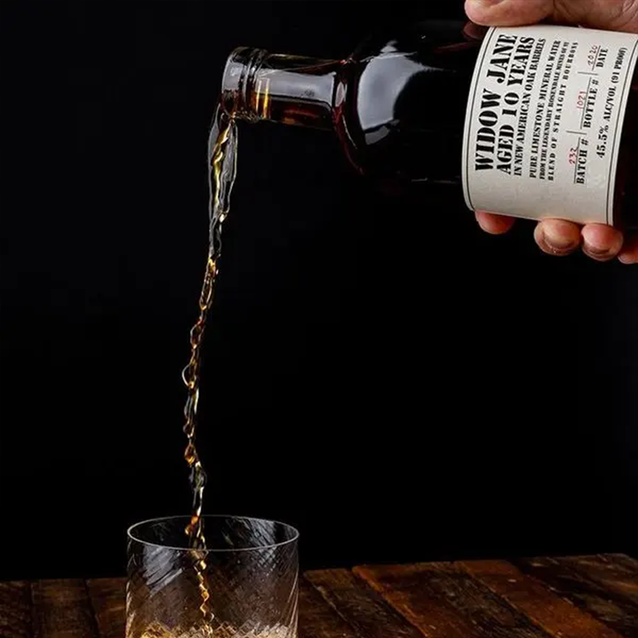 Widow Jane Aged 10 Year Bourbon being poured into a glass, showcasing its rich color and texture.