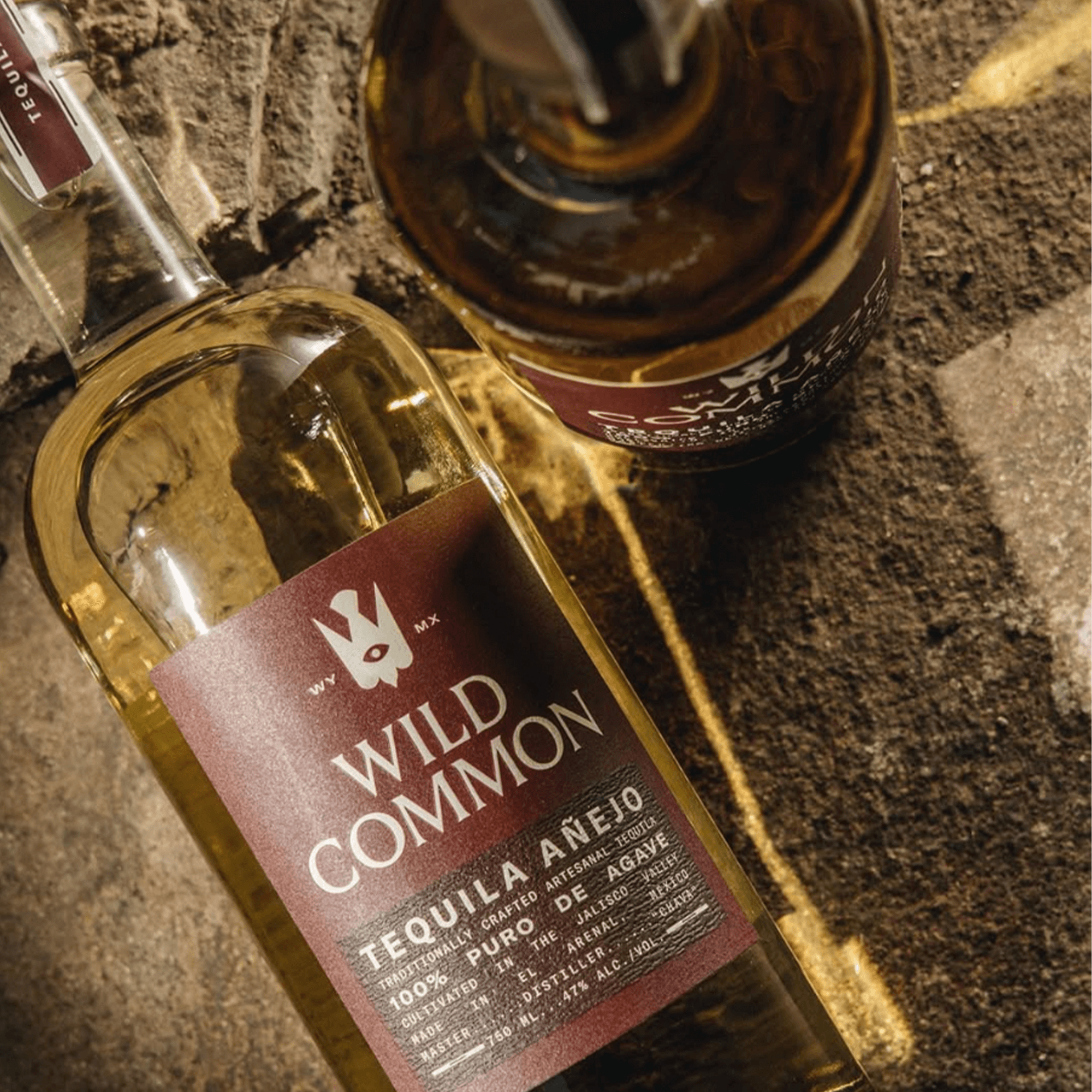 Bottle of Wild Common Añejo Tequila showcasing its rich straw color and elegant label design.