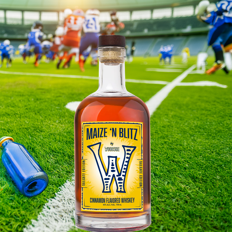 Woodson Maize N Blitz Tailgate Edition Cinnamon Flavored Whiskey on a football field with players in the background.