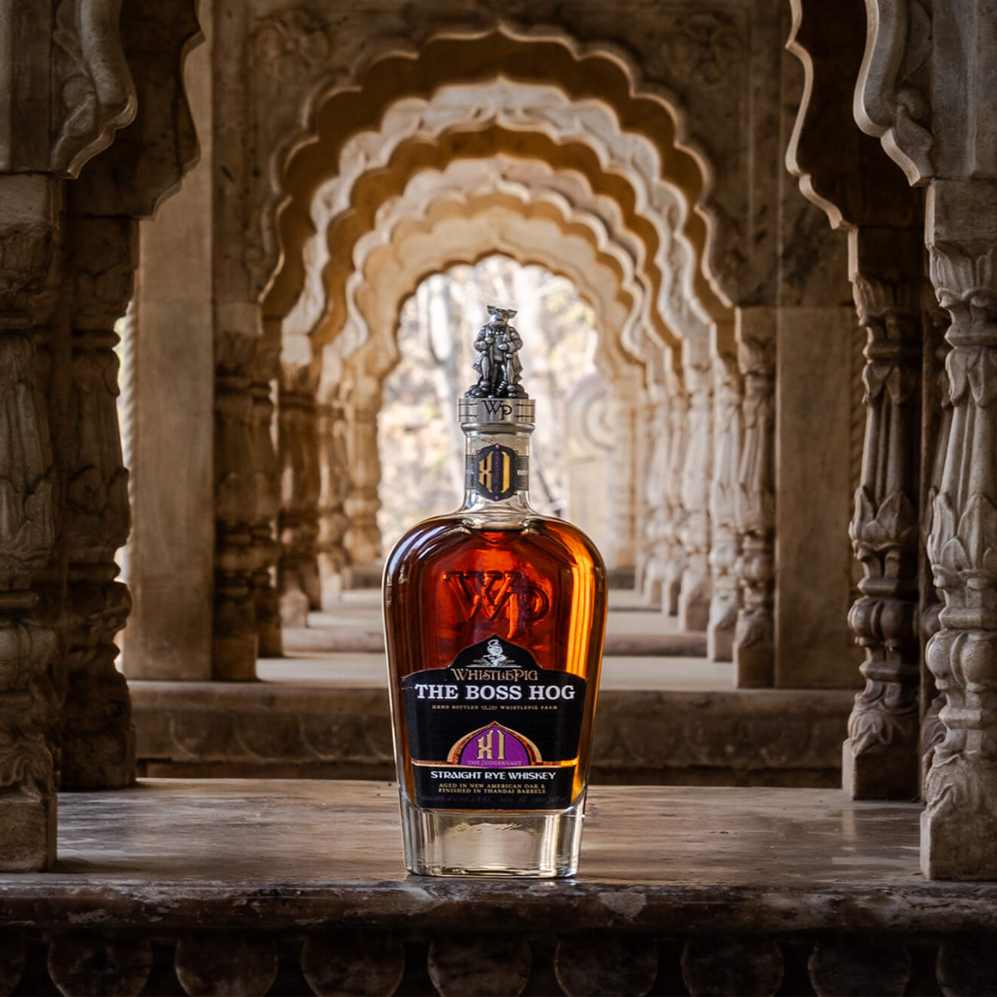 Whistlepig Boss Hog XI The Juggernaut Rye Whiskey bottle in ornate Indian architecture background.