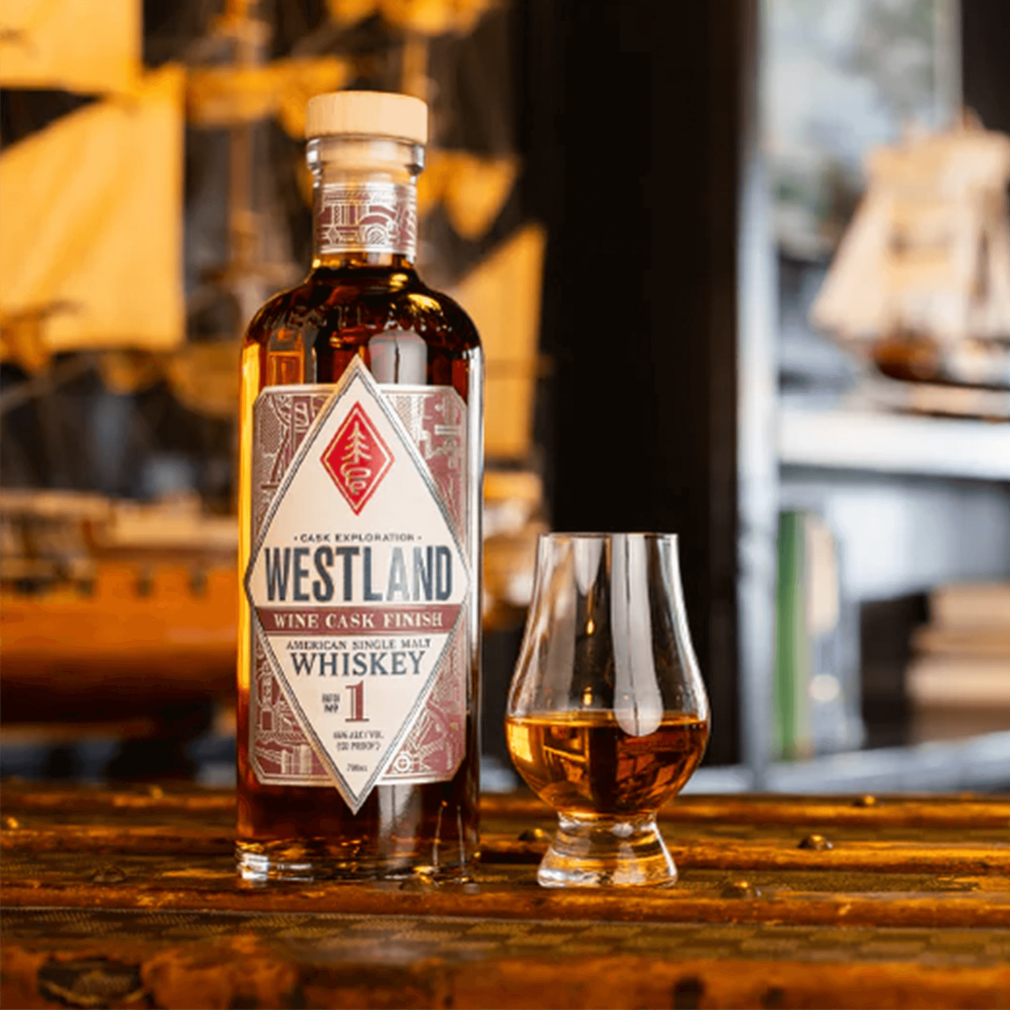 Westland Wine Cask Finish American Single Malt Whiskey Batch 1 with glass, showcasing rich amber color and intricate label.