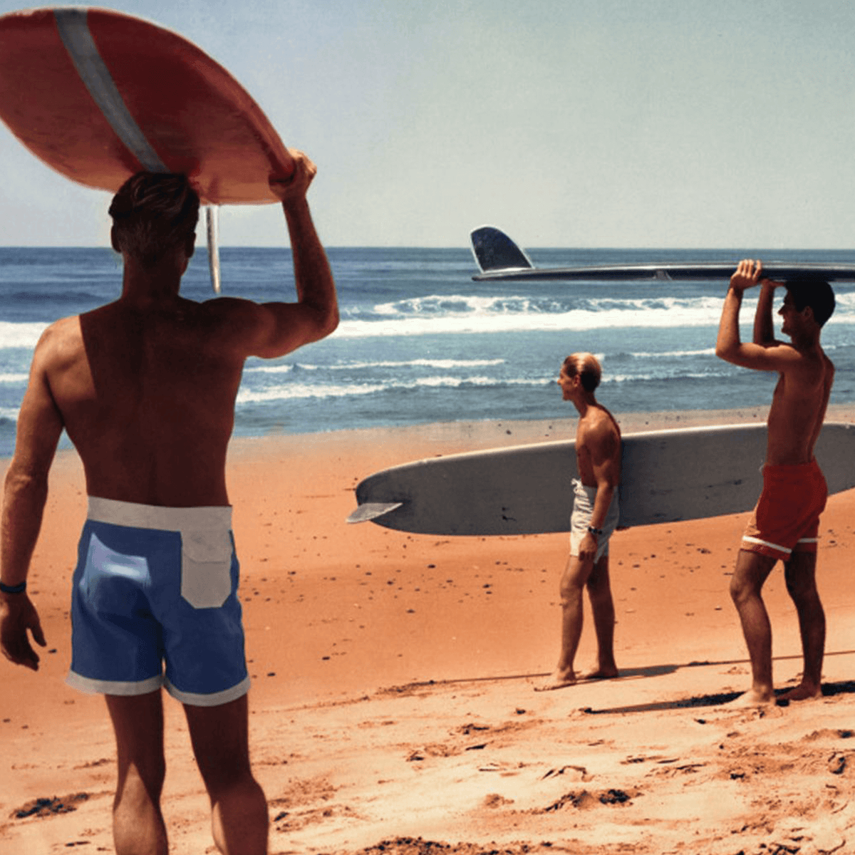 Three surfers with boards on a beach, capturing the spirit of adventure and the endless summer vibe.