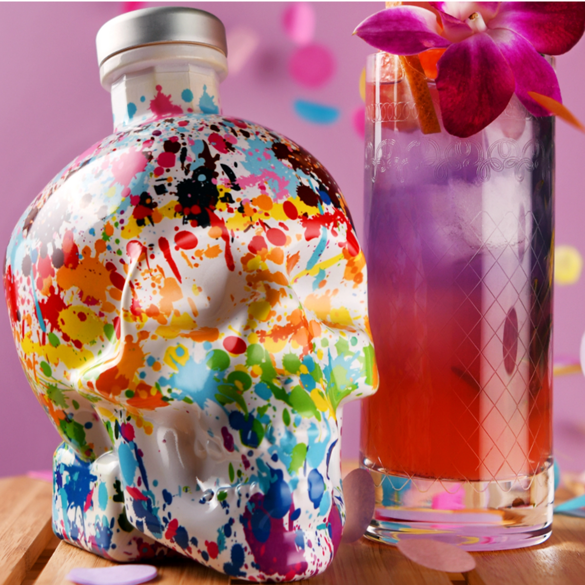 Crystal Head Vodka Pride Edition bottle with colorful paint splatter next to a vibrant cocktail, celebrating LGBTQ+ empowerment.