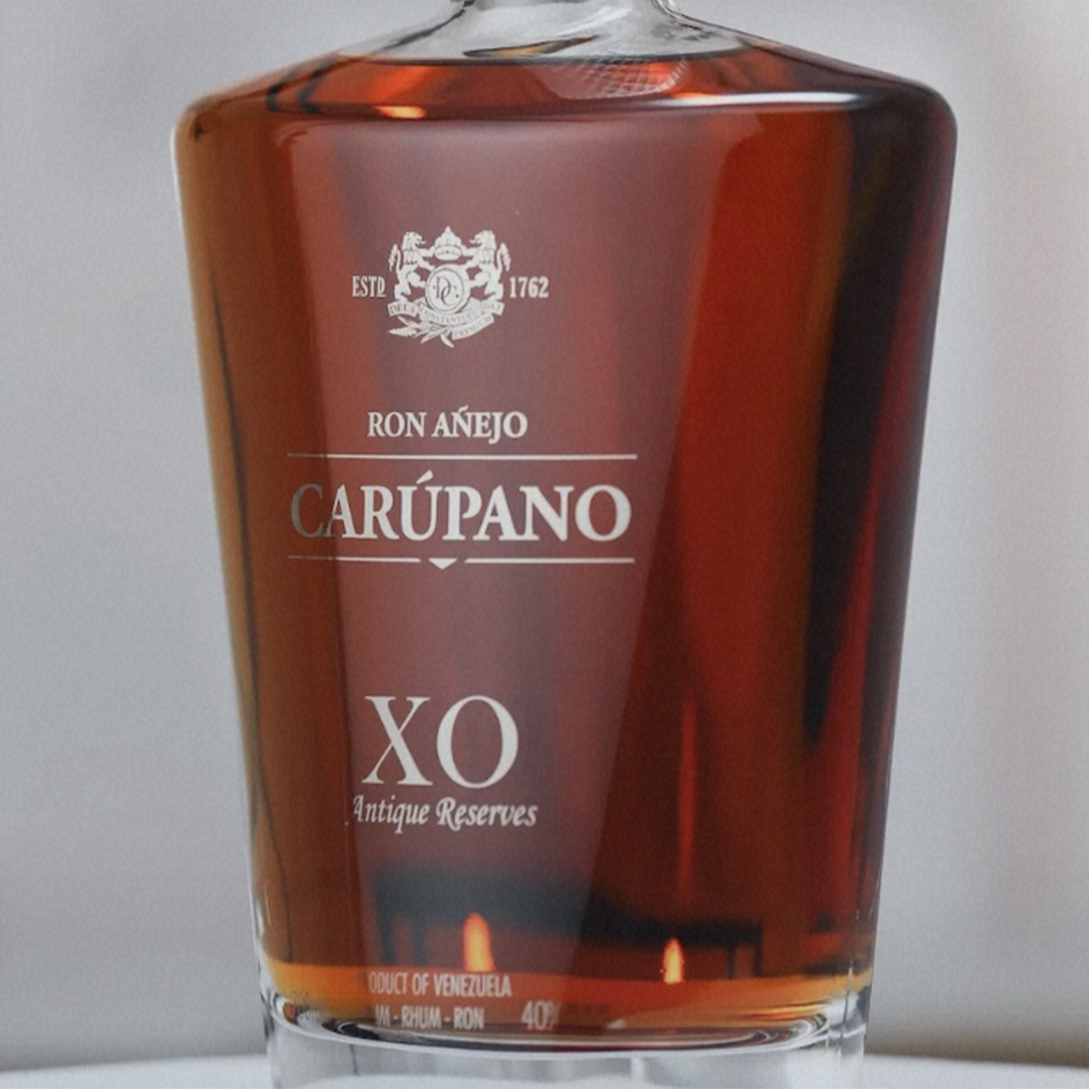 Ron Carupano Anejo X.O. Antique Reserve Rum in a crystal decanter, showcasing rich amber color and elegant design.