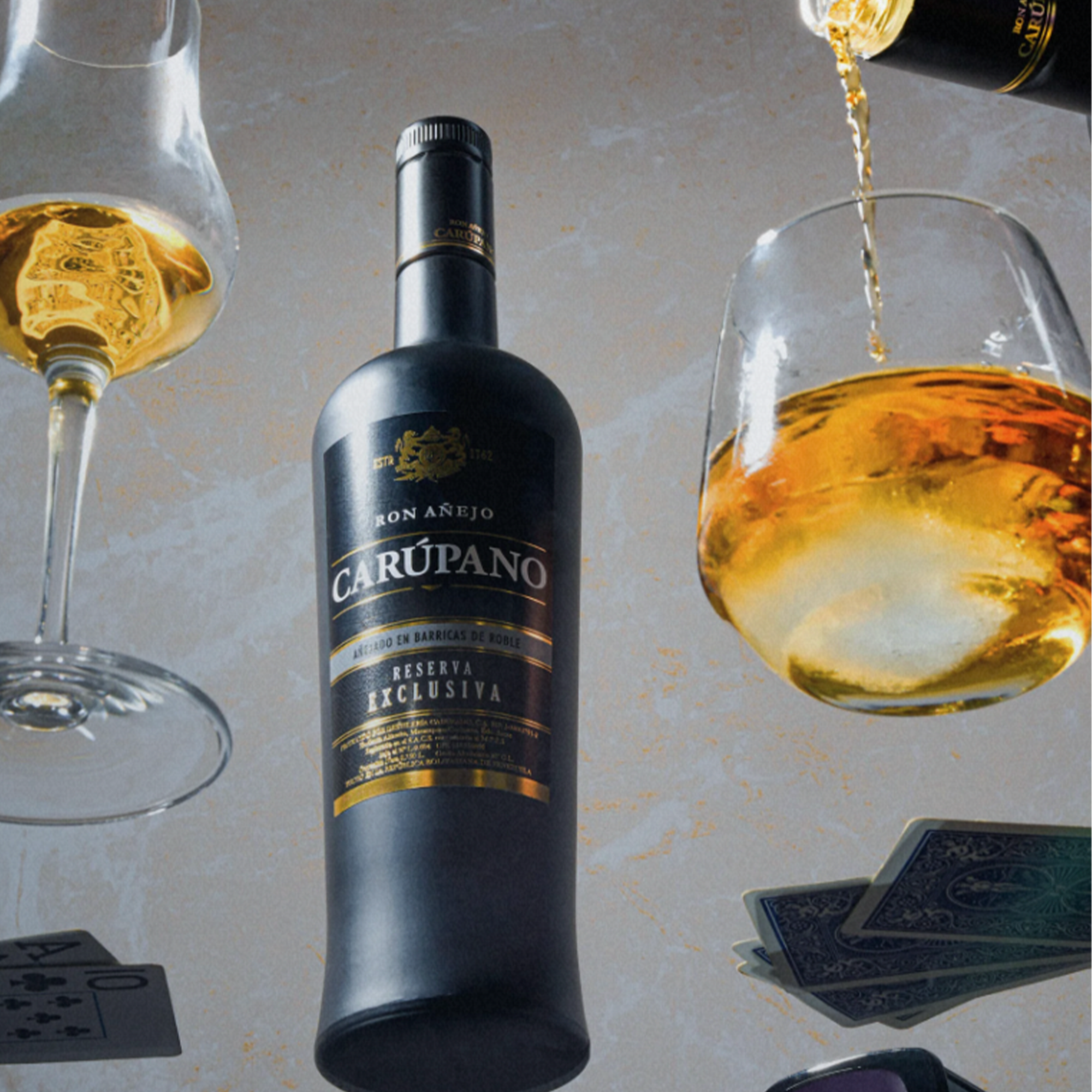 Ron Carupano Riserva Exclusiva 12 Year Rum bottle surrounded by glasses, showcasing amber rum and a sophisticated drinking experience.