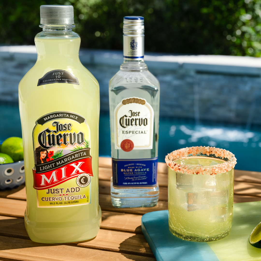 Jose Cuervo Classic Lime Light Margarita Mix and Especial tequila next to a glass of margarita by a pool.