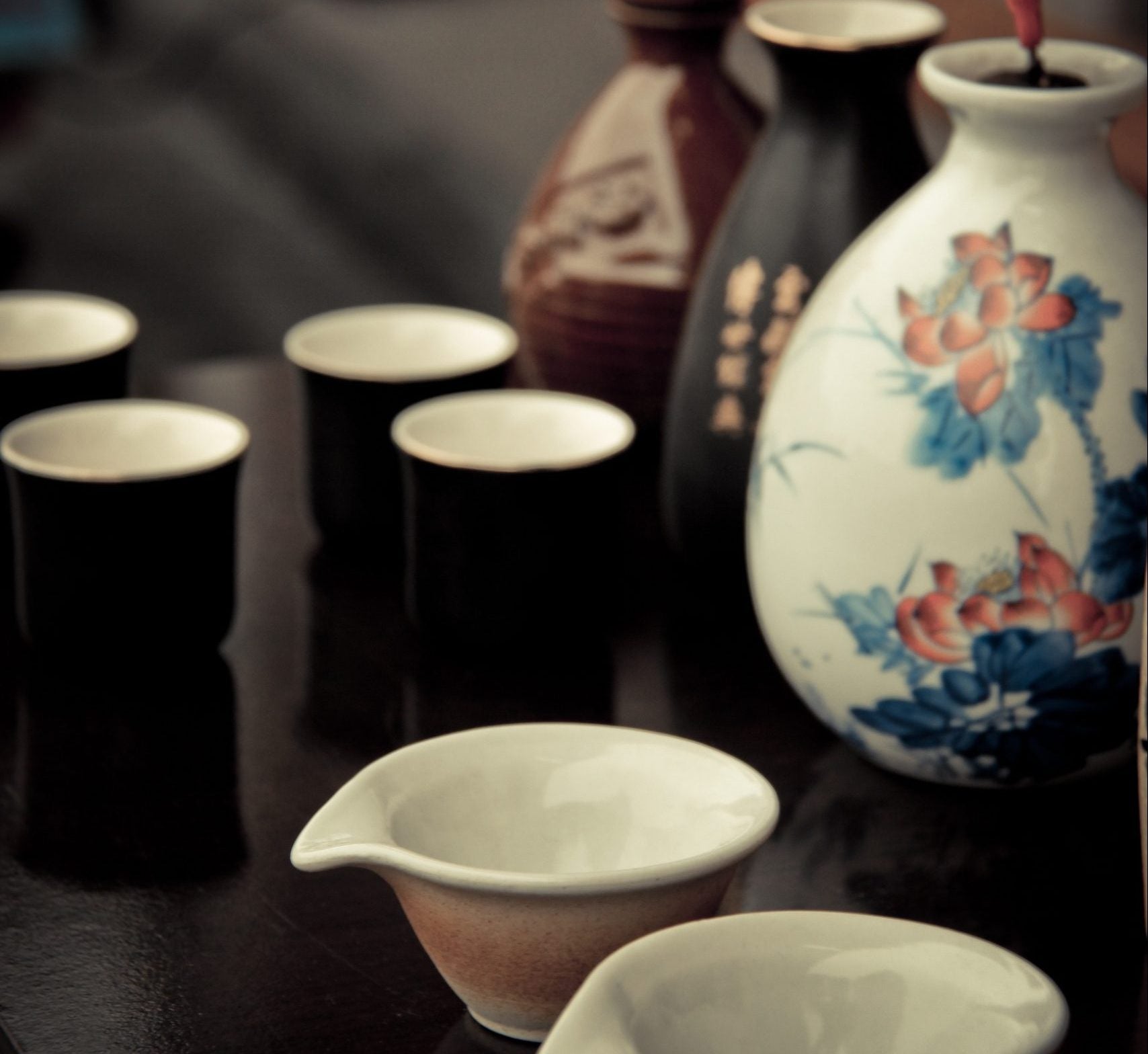 Traditional Korean soju set with ceramic cups and decorative bottle on a wooden table.