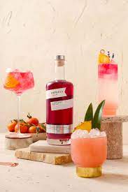 Empress 1908 Elderflower Rose Gin showcased with vibrant cocktails in a serene setting, highlighting its floral essence.