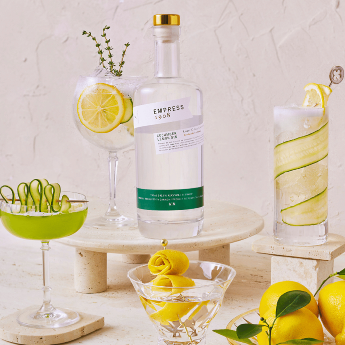 Empress 1908 Cucumber Lemon Gin bottle showcased with refreshing cocktails and garnishes on a stylish table.