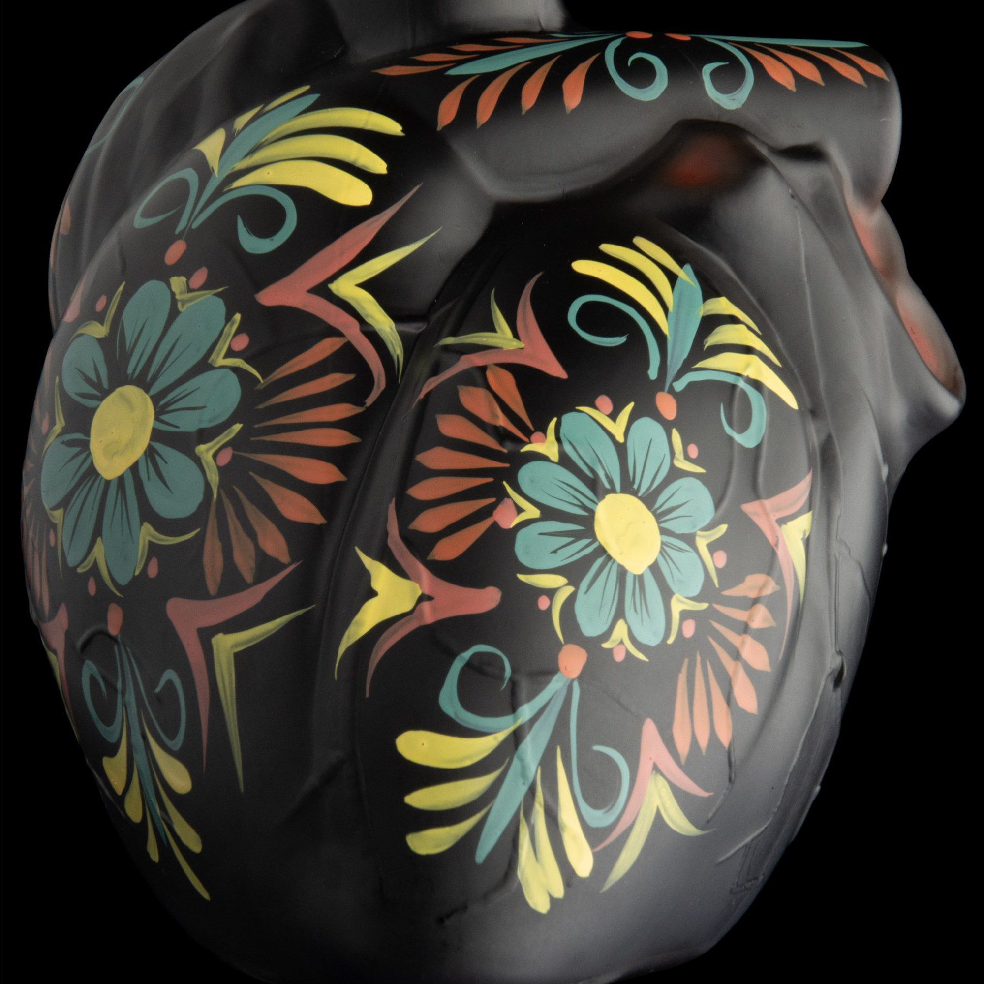Artistic bottle design of Sangre De Vida Añejo Tequila with colorful floral motifs on a black background.