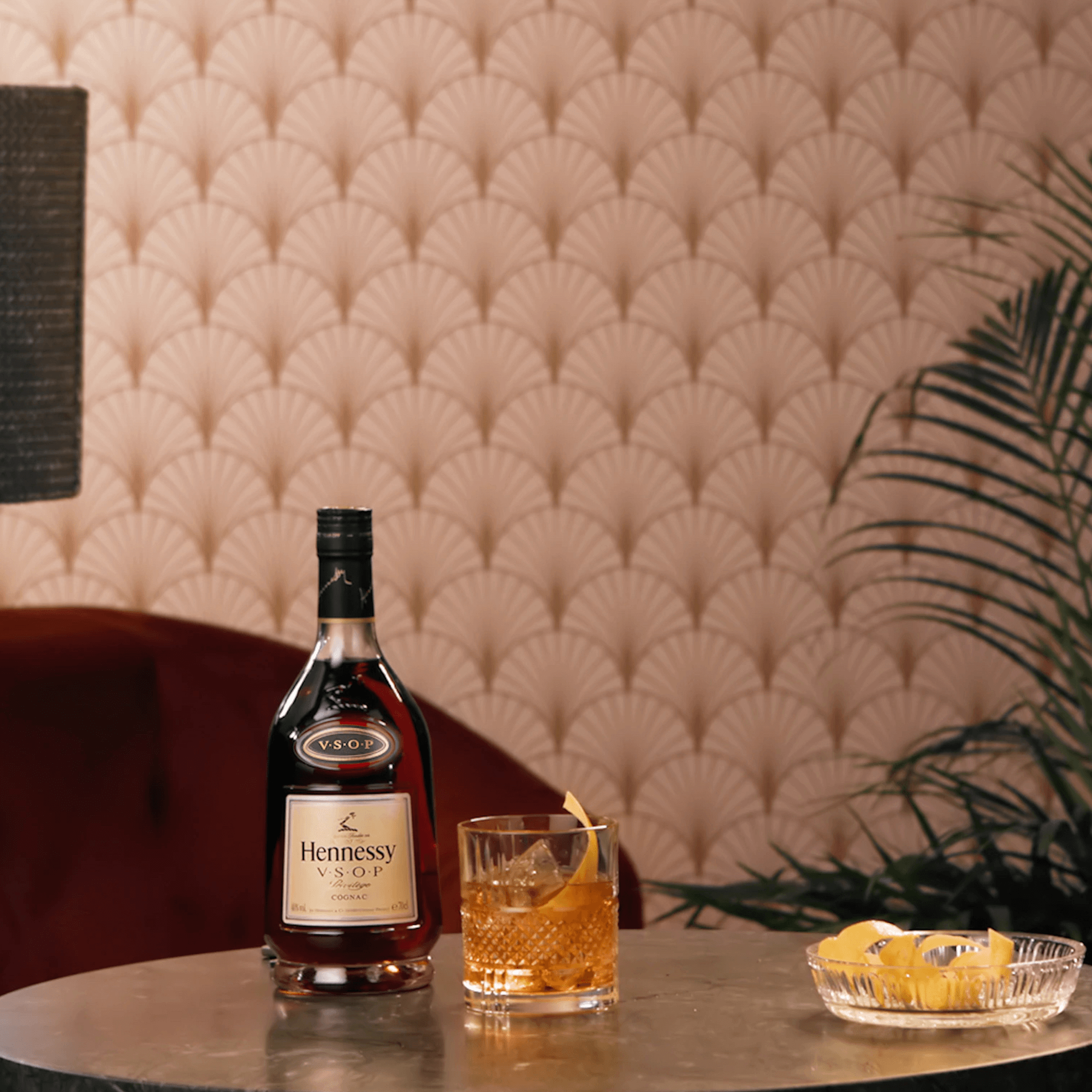 Hennessy VSOP Privilège cognac bottle with an elegant glass and lemon garnish on a stylish table.