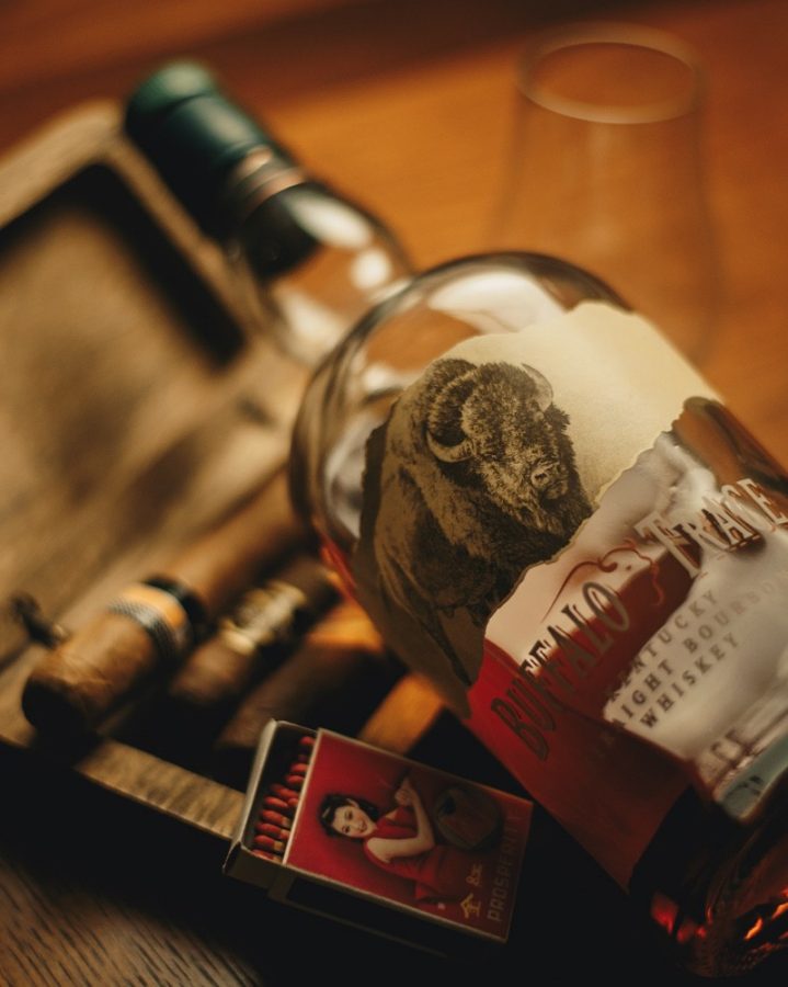 Buffalo Trace Kentucky Straight Bourbon bottle with a rustic background and a matchbox, showcasing the bourbon's heritage.
