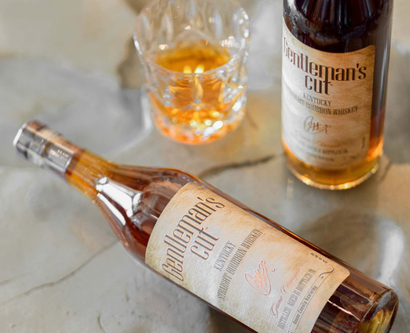 Gentleman's Cut Kentucky Straight Bourbon whiskey bottle with a glass of bourbon on a stone surface.